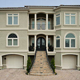 front of custom home with large brick stairs going up to entrance in the center