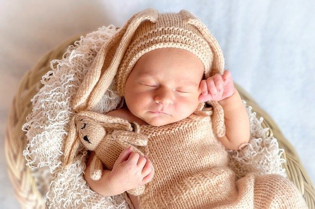 Newborn baby in white and gold clothes